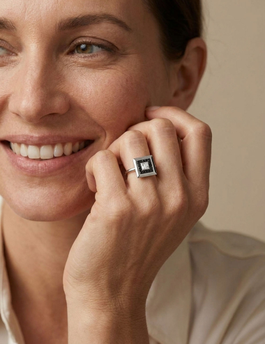 Select ring in white gold with a princess-cut white diamond and black diamonds worn by a woman.