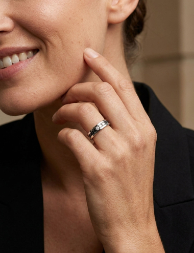 Trilogy Iconic ring in white gold with three white diamonds totaling 0.30 carat and black diamonds worn by a woman