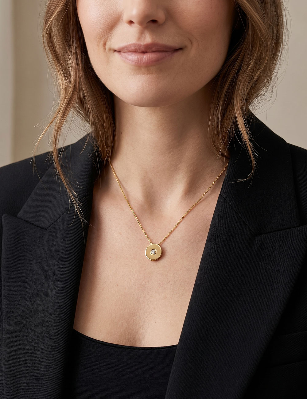 Pendentif Monade en or jaune 18 carats et diamant blanc naturel porté par une femme.