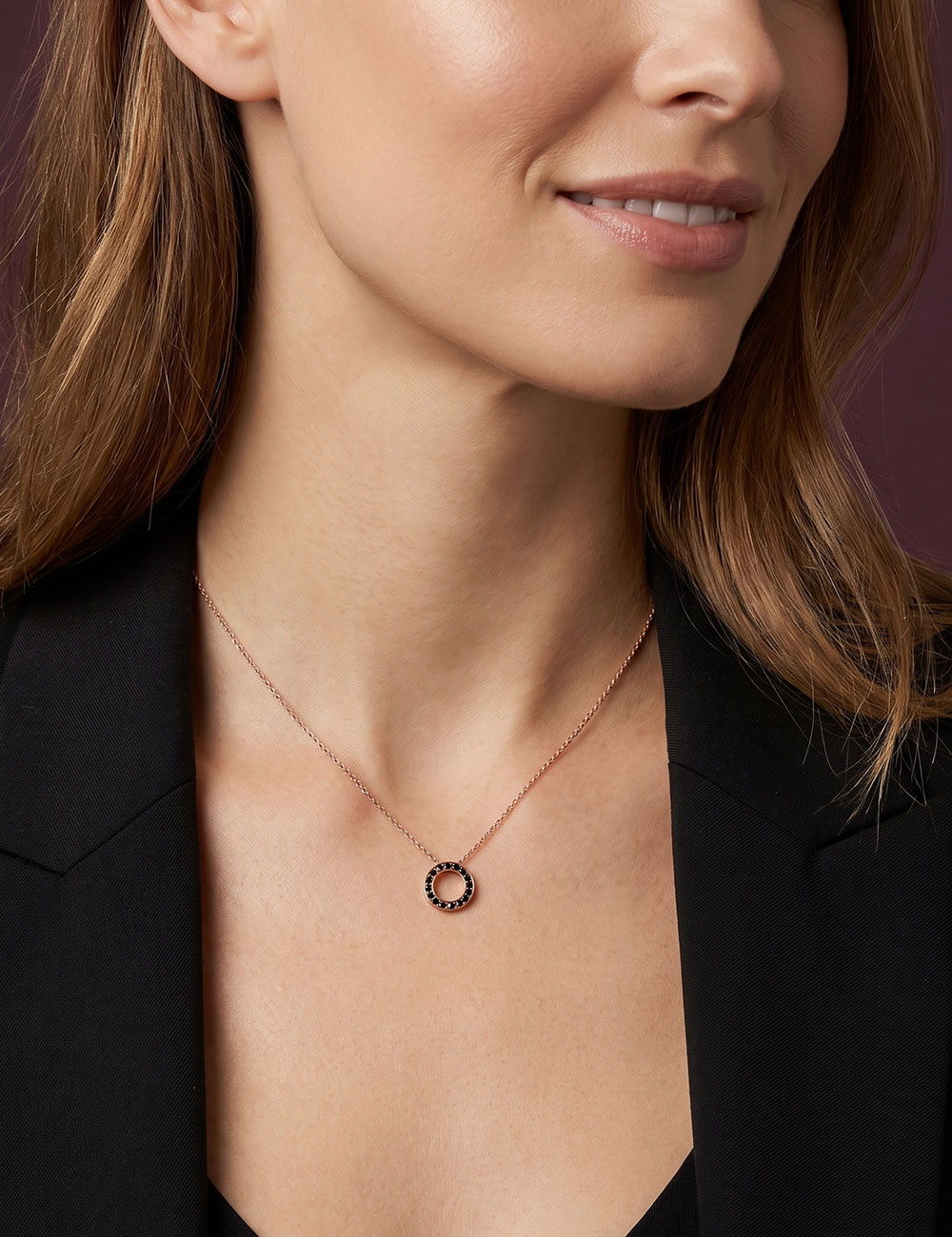 Pendentif Cercle en or rose 18 carats serti de diamants noirs porté par une femme.