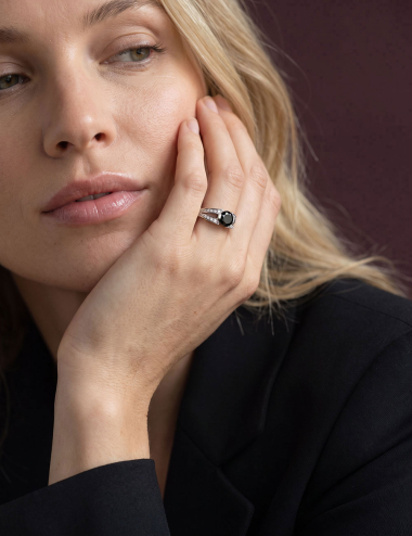 Sweet engagement ring in platinum, set with a 1-carat black diamond, worn by a woman.
