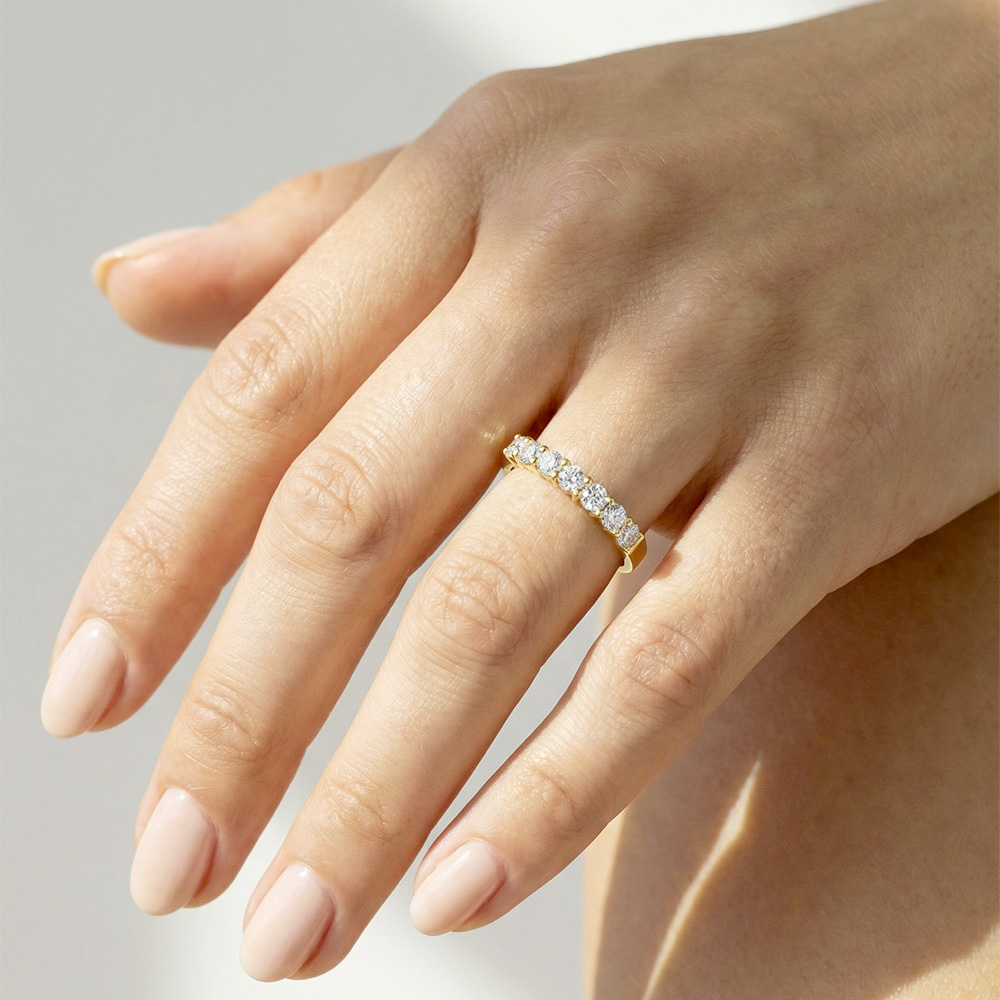 Alliance femme en or jaune avec diamants en serti griffes, design lumineux et contemporain.