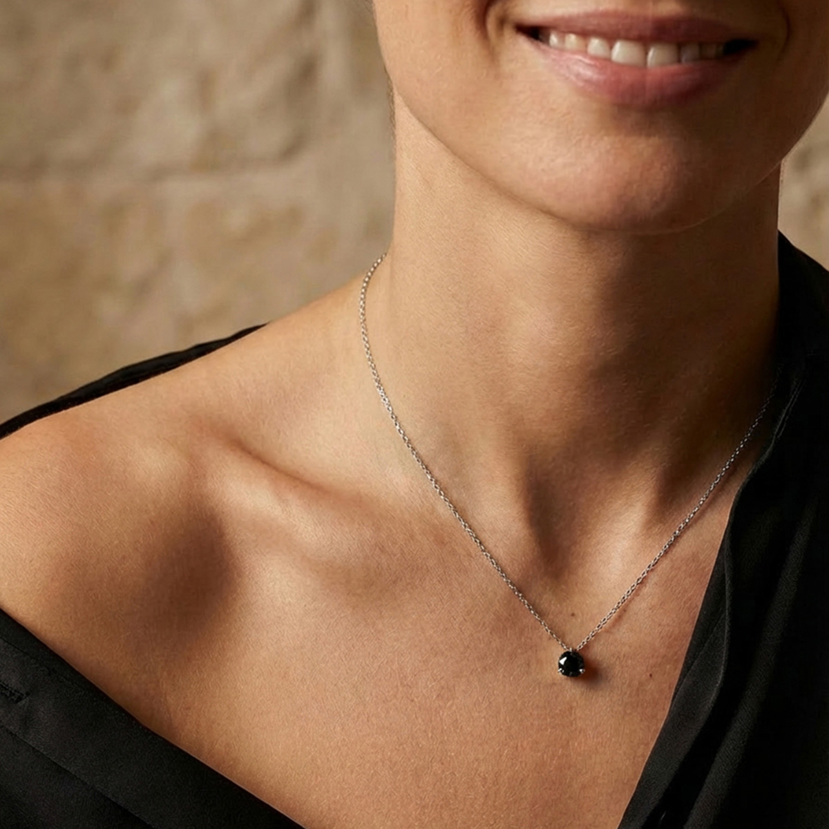Collier solitaire avec pendentif diamant noir taille brillant sur une chaîne fine en or blanc portée par une femme