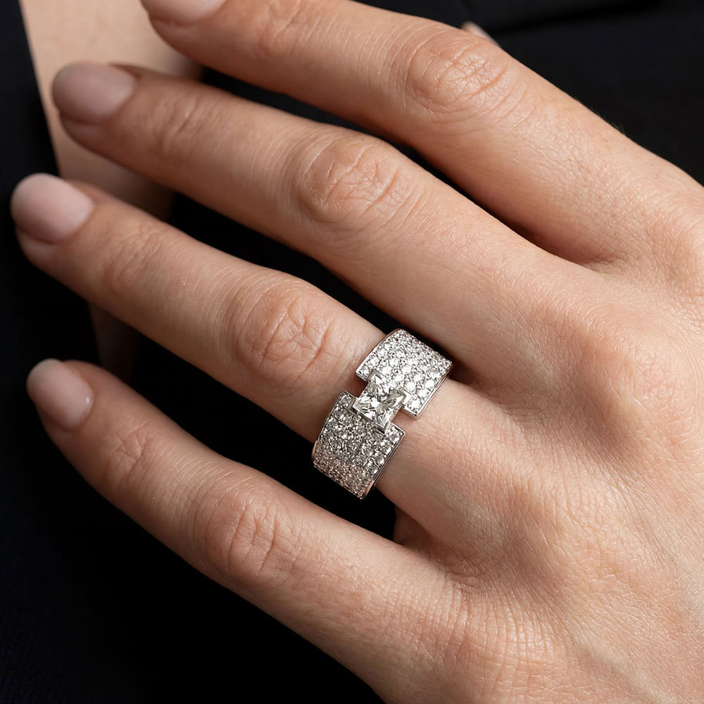 Engagement ring with a 0.60-carat princess-cut white diamond and white diamond pavé.