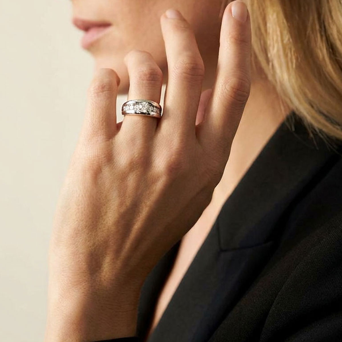 Soft platinum engagement ring with white diamonds, worn by a woman.
