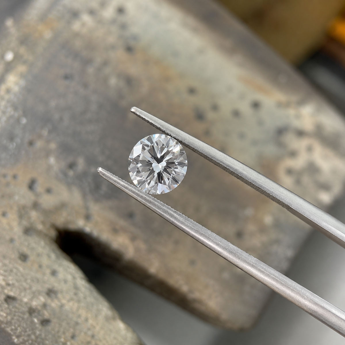 Natural white diamond held with jeweler's tweezers