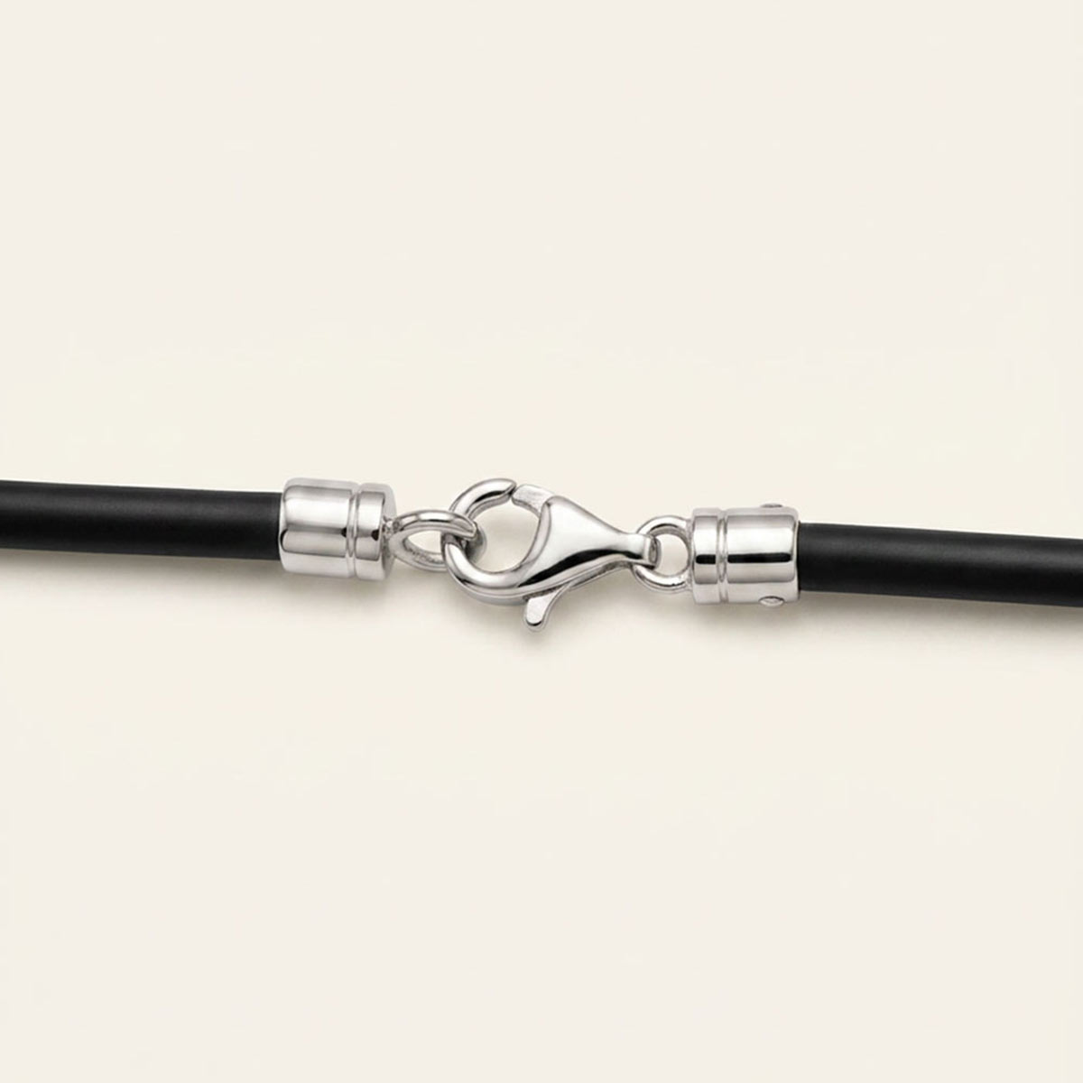 18k gold clasp and end caps on a black silicone cord necklace