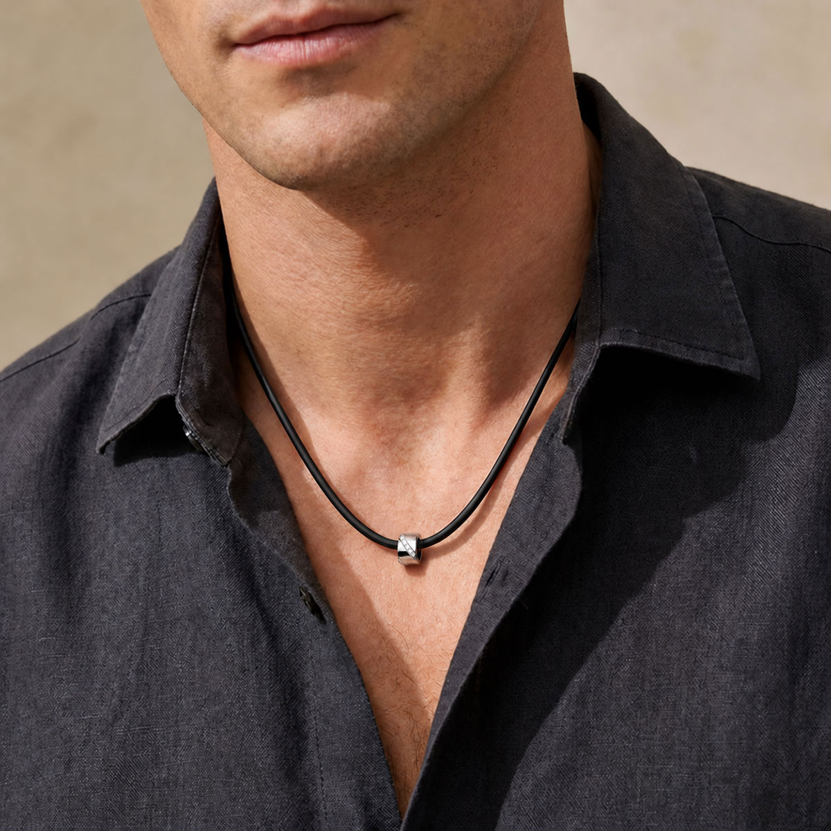Collier homme Wrapped in Love en or blanc 18 carats et diamants blancs, sur cordon en silicone noir porté.