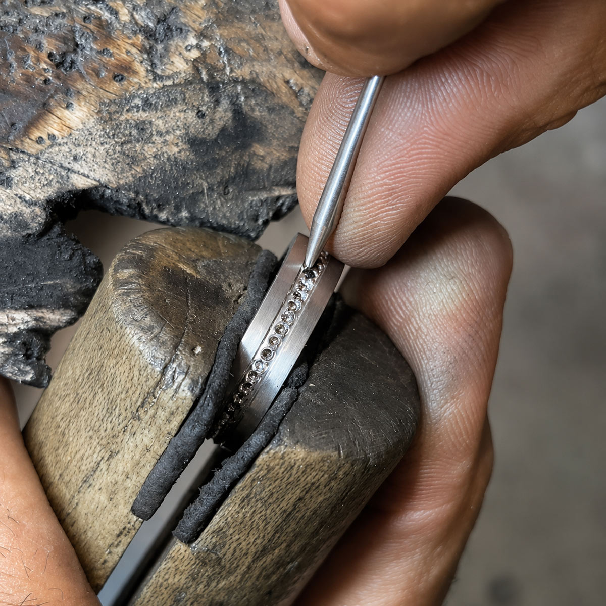 Sertissage d'une alliance diamants noirs dans notre atelier.