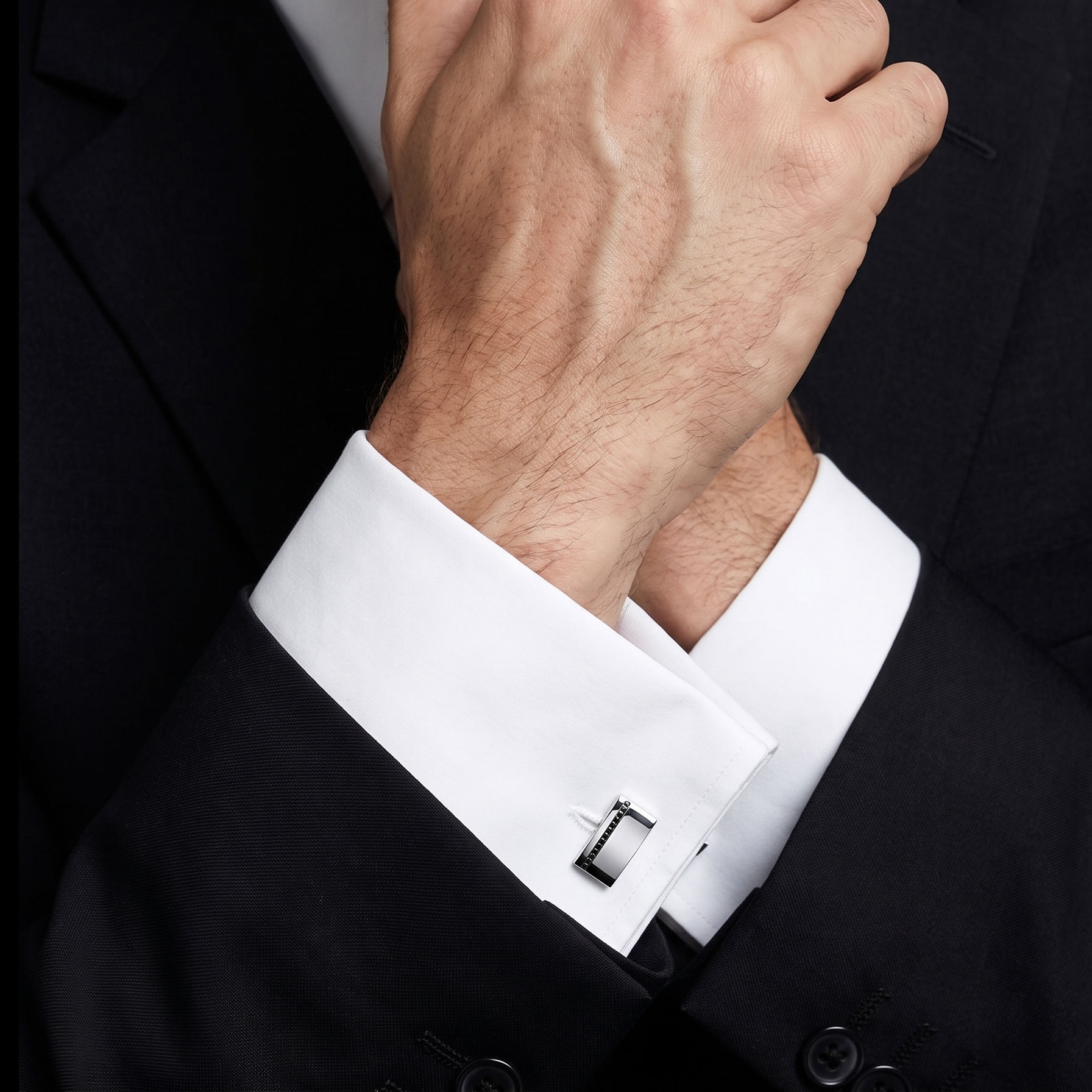 Perfect cufflinks in 18k white gold with a row of black diamonds, worn with a white French cuff shirt and a dark suit