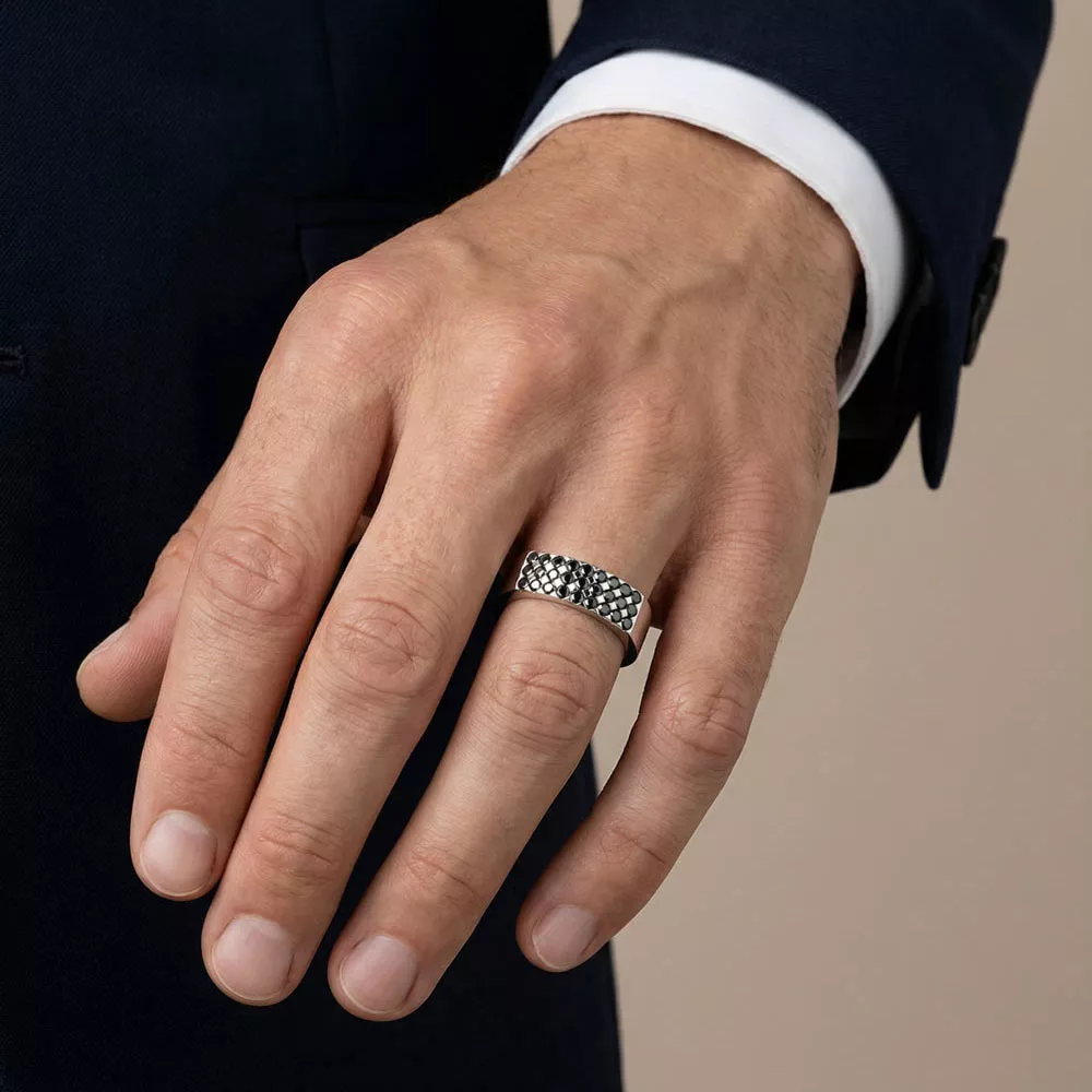 Chevalière homme en platine et pavage de diamants noirs porté par un homme.